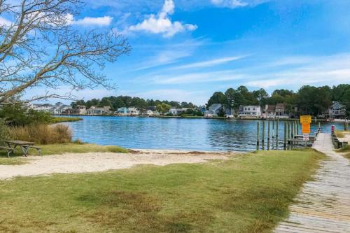 a view of a lake with benches and houses at Tranquil Woods in Ocean Pines