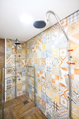 a bathroom with a shower with a mosaic wall at Flat Executivo GRU Airport in Guarulhos
