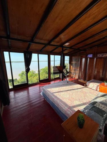 a bedroom with a large bed and large windows at El Amado in General Alvear