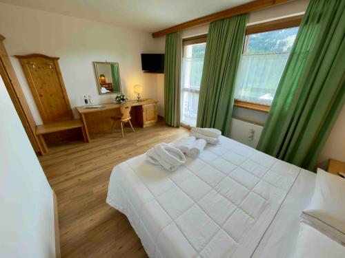 Un pat sau paturi într-o cameră la Hotel Mondeval