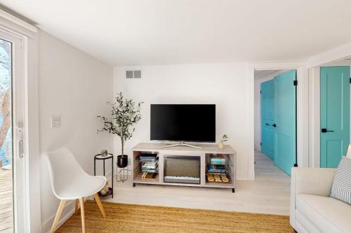 a white living room with a flat screen tv at Calm Waters in Bourne