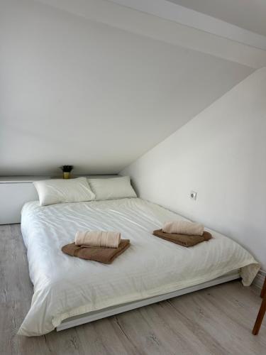 a large white bed with two pillows on it at Prestige in Arandelovac