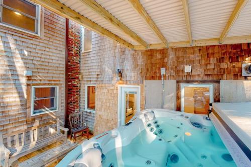 a hot tub in a room with a brick wall at Tranquil Getaway in Wellfleet