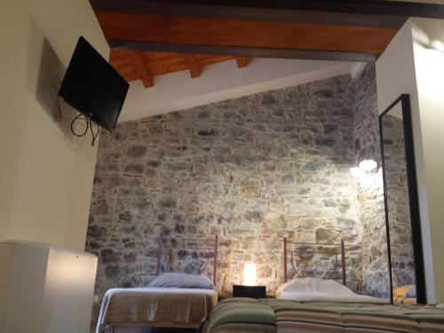 Pokój z 2 łóżkami i kamienną ścianą w obiekcie Bed & Breakfast Via Venezia w mieście Regalbuto