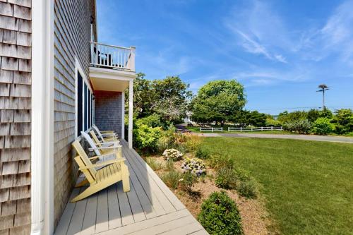 a porch with a bench on the side of a house at Harbor Point Cottage in Bourne