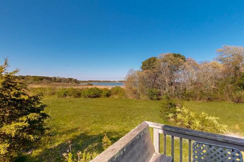 a bench in a field with a view of the water at Soundmeadow House in Oak Bluffs