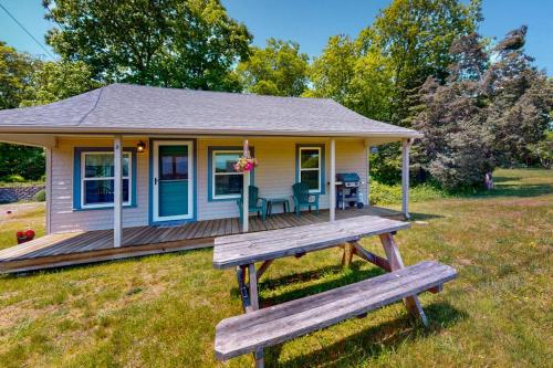 a tiny house with a bench in front of it at Cataumet Cottage in Bourne