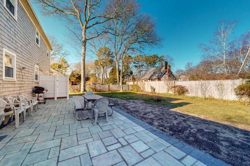 a patio with a table and chairs and a fence at Cape Estate 6 in South Dennis