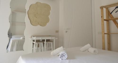 a white room with two beds and a table at Casa Nannì in Polignano a Mare