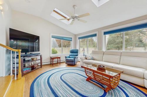 a living room with a couch and a tv at Wharf Side Hideout in Hyannis