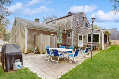 a patio with a table and chairs in front of a house at Wharf Side Hideout in Hyannis