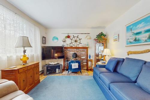 a living room with a blue couch and a fireplace at Hyannis Beach House in Hyannis