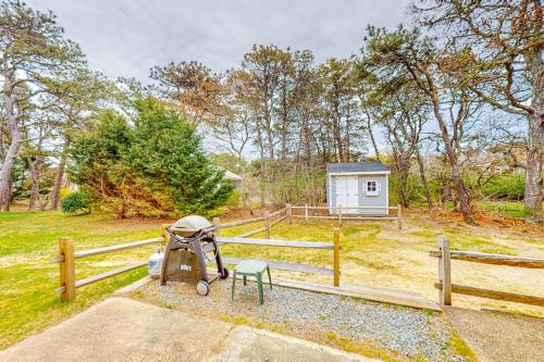a yard with a wooden fence and a playground at Nauset Beach Buddy in Orleans