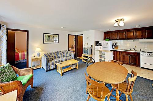 a living room with a table and a kitchen at Dennis Port Palace in Dennis Port