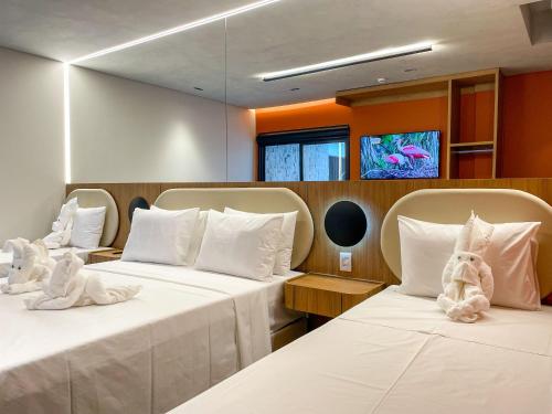 two beds with stuffed animals on them in a room at Pousada Villas Bonito in Bonito