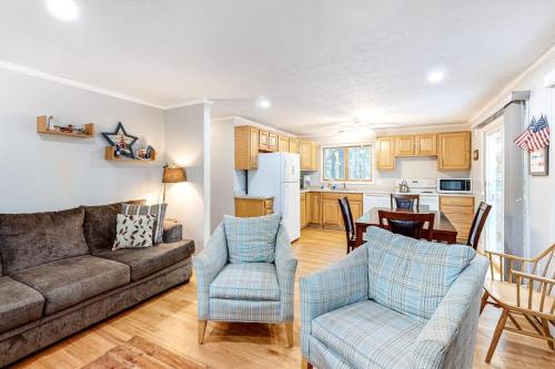 a living room with a couch and chairs and a kitchen at Lighthouse Lodge in Eastham