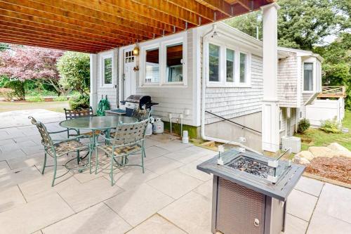 a patio with a table and chairs and a grill at Beach Happy in Harwich Port