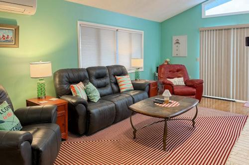 a living room with a leather couch and a table at Cherry Fish North in Beulah