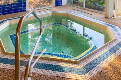 a pool with a tiled floor and stairs in a house at Ocean Edge Retreat in Brewster