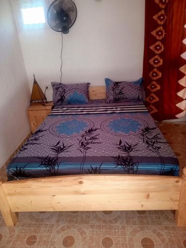 a wooden bed with a purple comforter in a bedroom at Cafe Romantique - Landhouse Style in Mérina