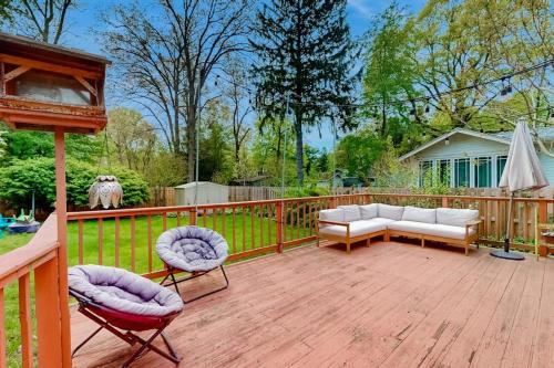 a patio with two couches and chairs on a wooden deck at Steps from the Sand in Union Pier
