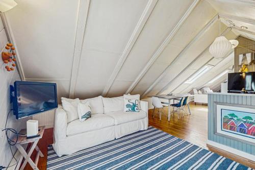 a living room with a white couch and a tv at Monument View in Provincetown