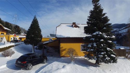 a car parked in front of a house with a snow covered roof at Sun Chalet in Schladming