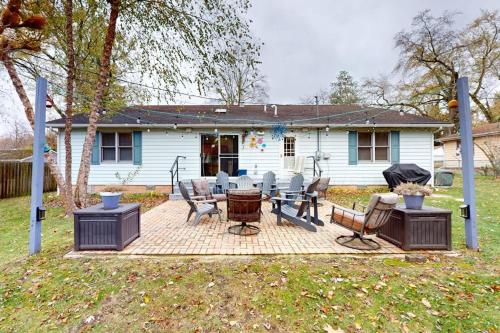a patio with a table and chairs in front of a house at Four Bedrooms & a Beach in Lakeside