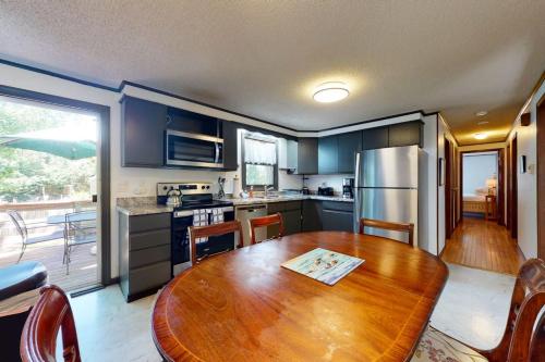 a kitchen with a wooden table and a refrigerator at Sea Glen Cottage in Oak Bluffs