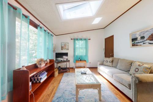 a living room with a couch and a tv at Sea Glen Cottage in Oak Bluffs