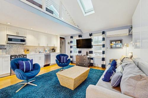a living room with a couch and chairs and a kitchen at Provincetown Waterfront Studio in Provincetown