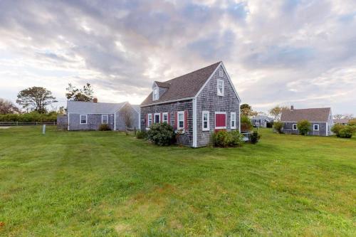 a house in a field with a grass yard at Sea Coast Cottage in Barnstable