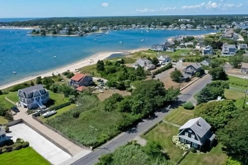 an aerial view of a house and the water at Bayview Bliss in West Yarmouth