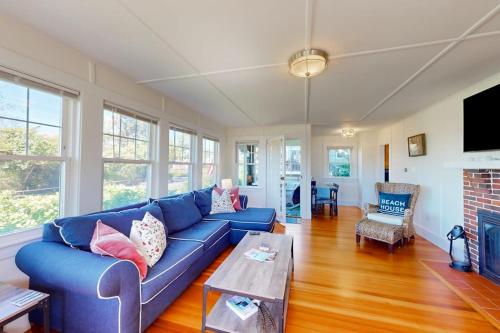 a living room with a blue couch and a table at Bayview Bliss in West Yarmouth