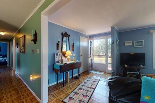 a living room with blue walls and a table and a couch at Summer Get Away in Dennis Port