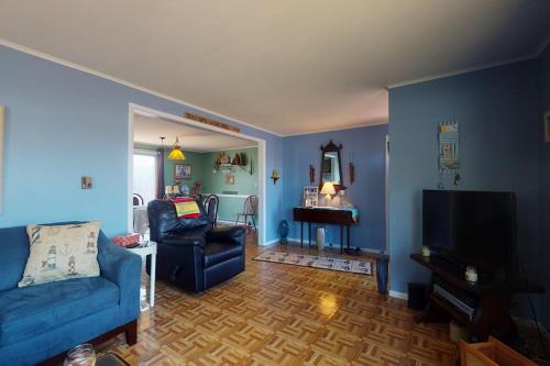 a living room with blue walls and a blue couch at Summer Get Away in Dennis Port