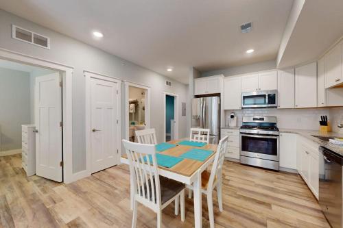 a kitchen with white cabinets and a table and chairs at Cozy TC Bay Condo in Traverse City