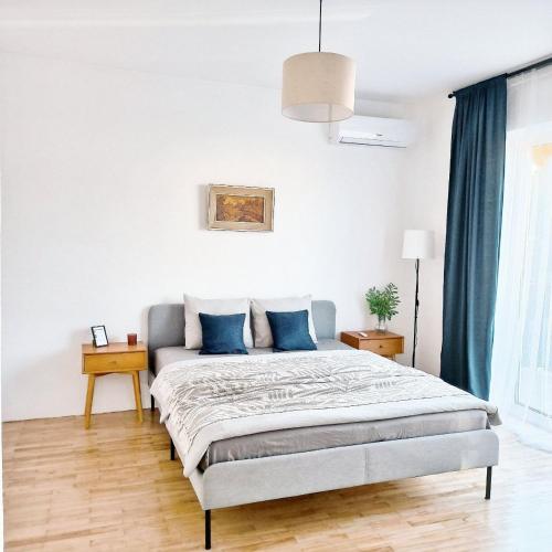 a bedroom with a large bed with blue pillows at GuestHouse Maison Standard in Kula