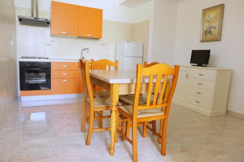 een keuken met een tafel en stoelen en een fornuis bij Appartamento Roberti in Corsano