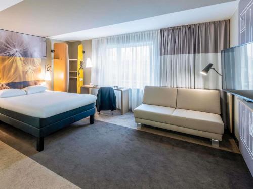 a hotel room with a bed and a couch at ibis Luebeck City in Lübeck