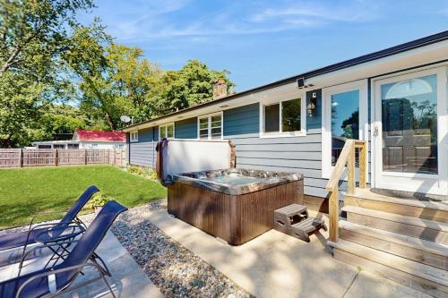 a backyard with a hot tub and two chairs at Charlotte’s Chateau in New Buffalo