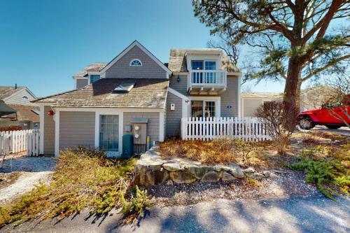 a house with a white fence in front of it at Maushop Village Beach Getaway in Mashpee