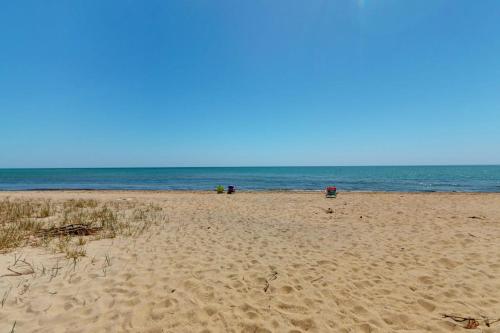 a beach with people sitting on the sand and the ocean at Maushop Village Beach Getaway in Mashpee