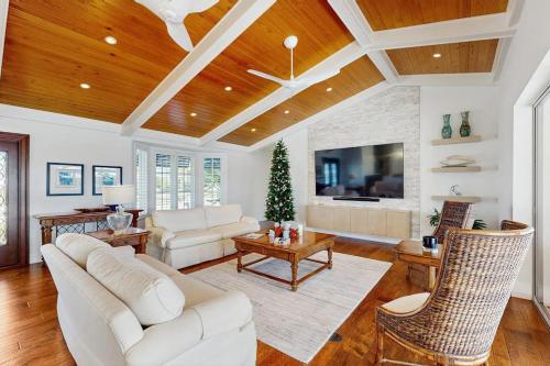 a living room with white furniture and a christmas tree at Dock Holiday in Marco Island
