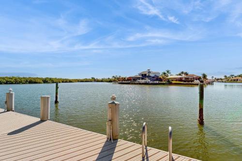 a dock on a large body of water with houses at Dock Holiday in Marco Island