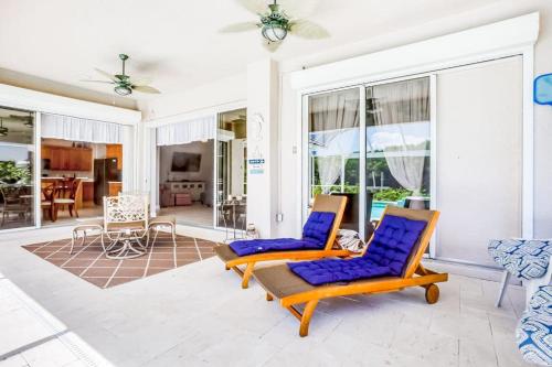 two chairs in a living room with windows at Cape Coral Haven in Cape Coral