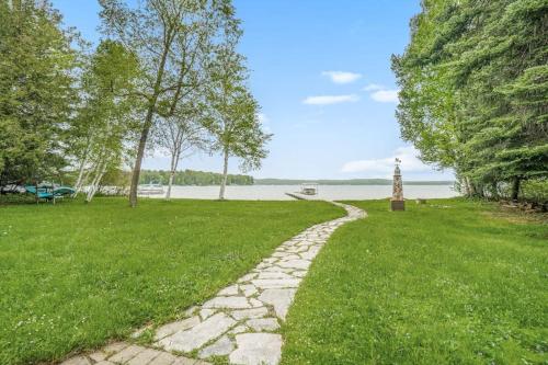 a stone path through a park with a lake in the background at Platte Lake Paradise in Beulah