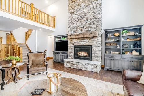 a living room with a stone fireplace and a staircase at Buckaroo in Thompsonville