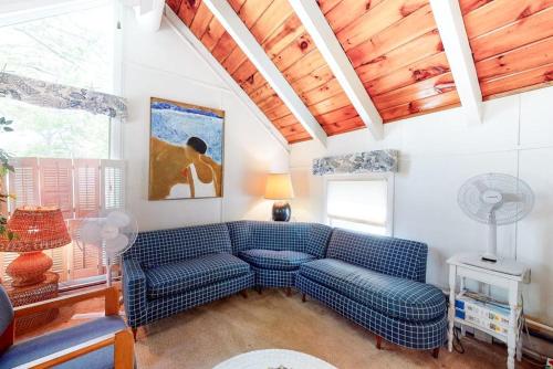 ein Wohnzimmer mit einem blauen Sofa und einem Tisch in der Unterkunft Summersea in Mashpee