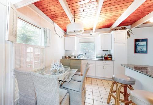 eine Küche mit weißen Schränken, einem Tisch und Stühlen in der Unterkunft Summersea in Mashpee